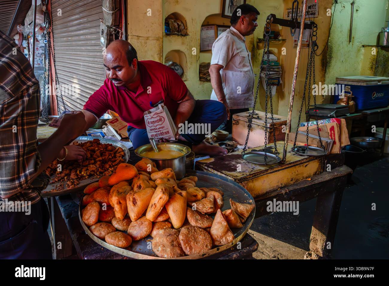 Venditrice di Street food che prepara spuntini locali a Jaipur, India Foto Stock