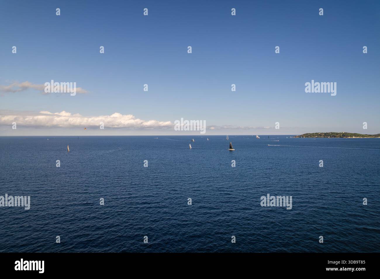 Vista aerea del tranquillo e profondo mare blu punteggiato da barche a vela bianche sullo sfondo della costa verdeggiante, Sainte-Maxime, Provence-Alpes-Co Foto Stock