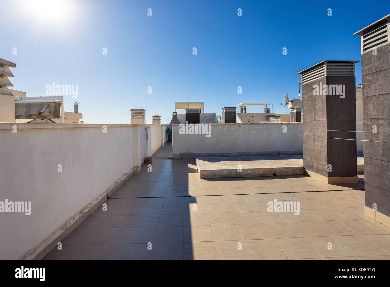 Grande tetto piastrellato con area grill, spazio illuminato dal sole e torri di ventilazione multiple Foto Stock