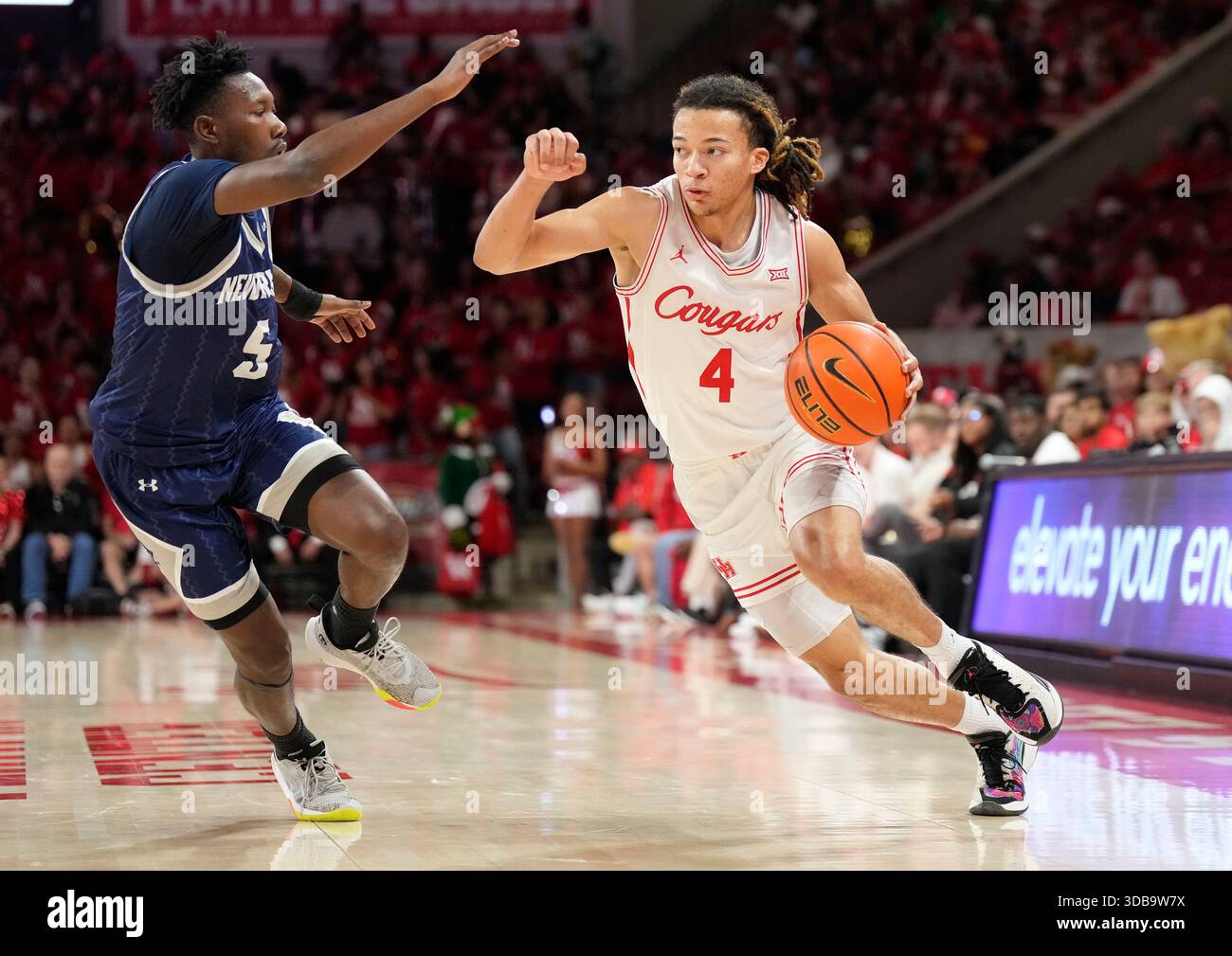 Houston guard Kingston Flemings (4) drives around New Orleans guard Jakevion Buckley (5) during the second half of an NCAA college basketball game, Saturday, Dec. 13, 2025, in Houston. (AP Photo/Karen Warren) Foto Stock