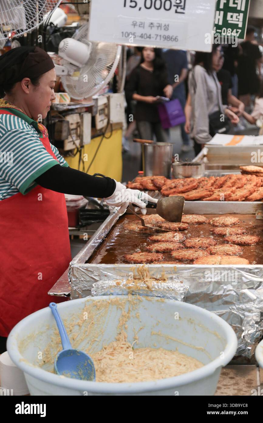 Donna coreana che cucina al tradizionale mercato alimentare di seoul Foto Stock
