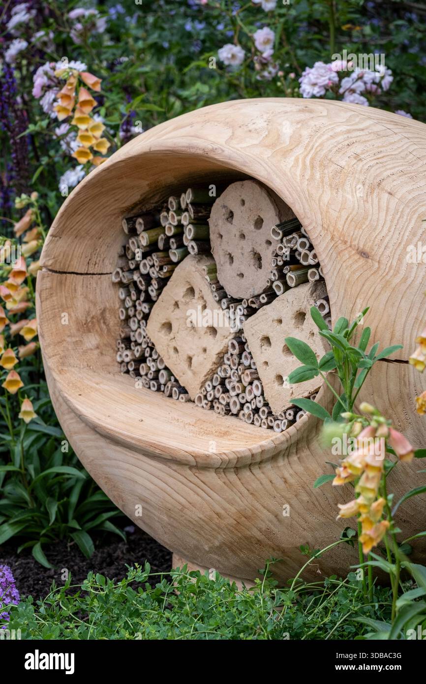 Hotel su misura per insetti in legno, circondato da giardini e animali selvatici Foto Stock