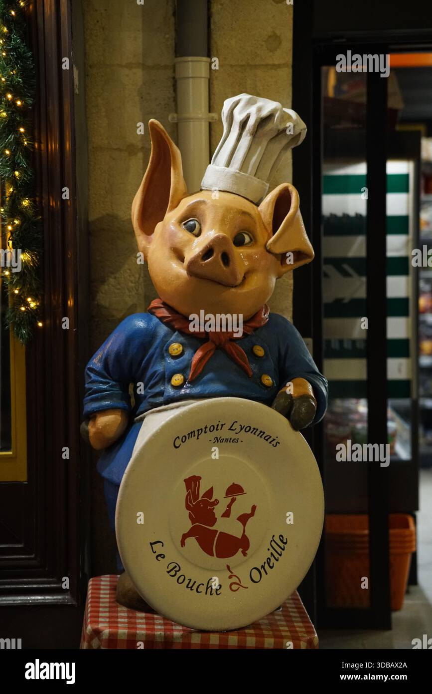 Statua dello chef a forma di maiale esposta all'esterno di un negozio di alimentari nel centro di Nantes, Francia Foto Stock