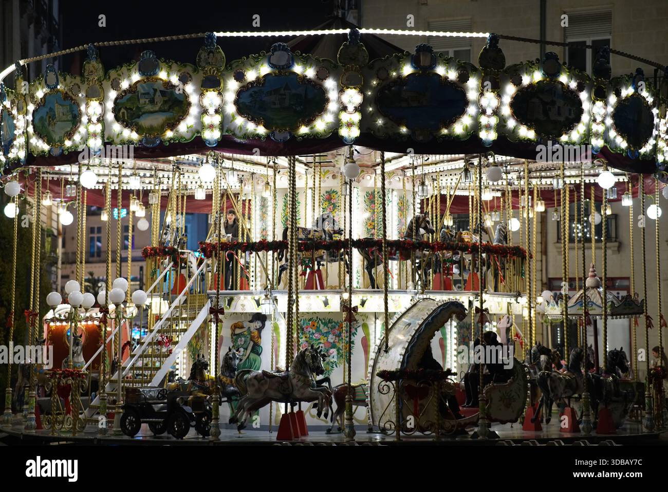 Giostra d'epoca illuminata che opera di notte durante un evento festivo nel centro di Nantes, Francia. Nantes, Francia Foto Stock