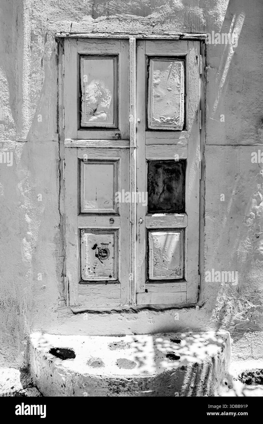 Porta di legno intemprata su un tradizionale edificio dipinto di bianco nella città di Mykonos, Cicladi, Grecia. Foto Stock