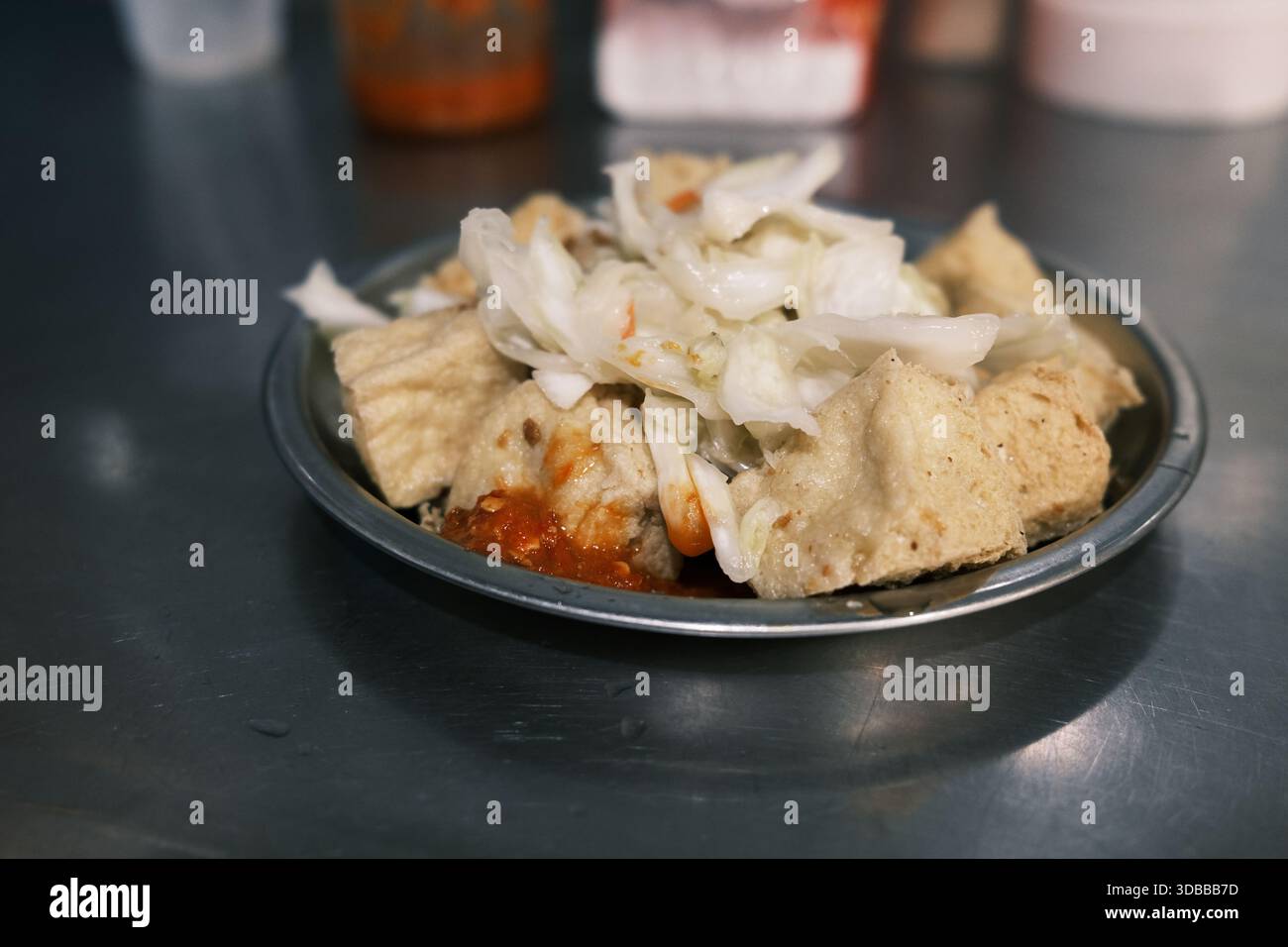 Stinky Tofu fritto croccante (Chou Dou fu), un famoso Street food taiwanese, servito su un piatto con salsa salata e cavolo sottaceto. Foto Stock