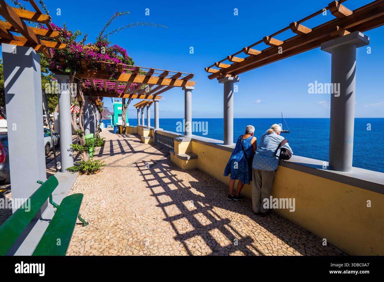 Splendida vista di una coppia di anziani appoggiata sulla banister e godendo della vista sopraelevata dell'Oceano Atlantico da Funchal a Madeira, in Portogallo Foto Stock