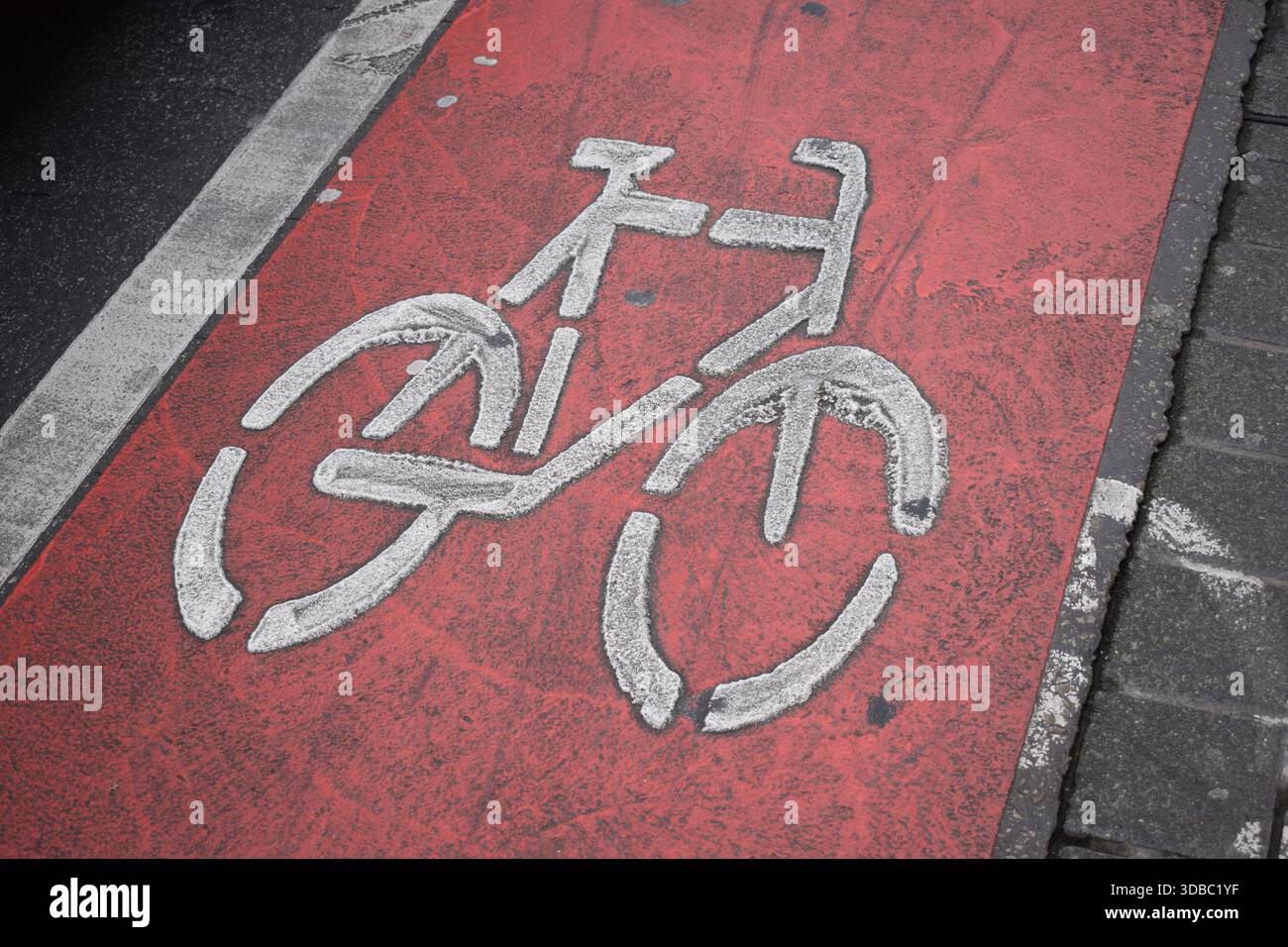 Strada per biciclette verniciata di rosso in Germania, scivolosa quando bagnata Foto Stock