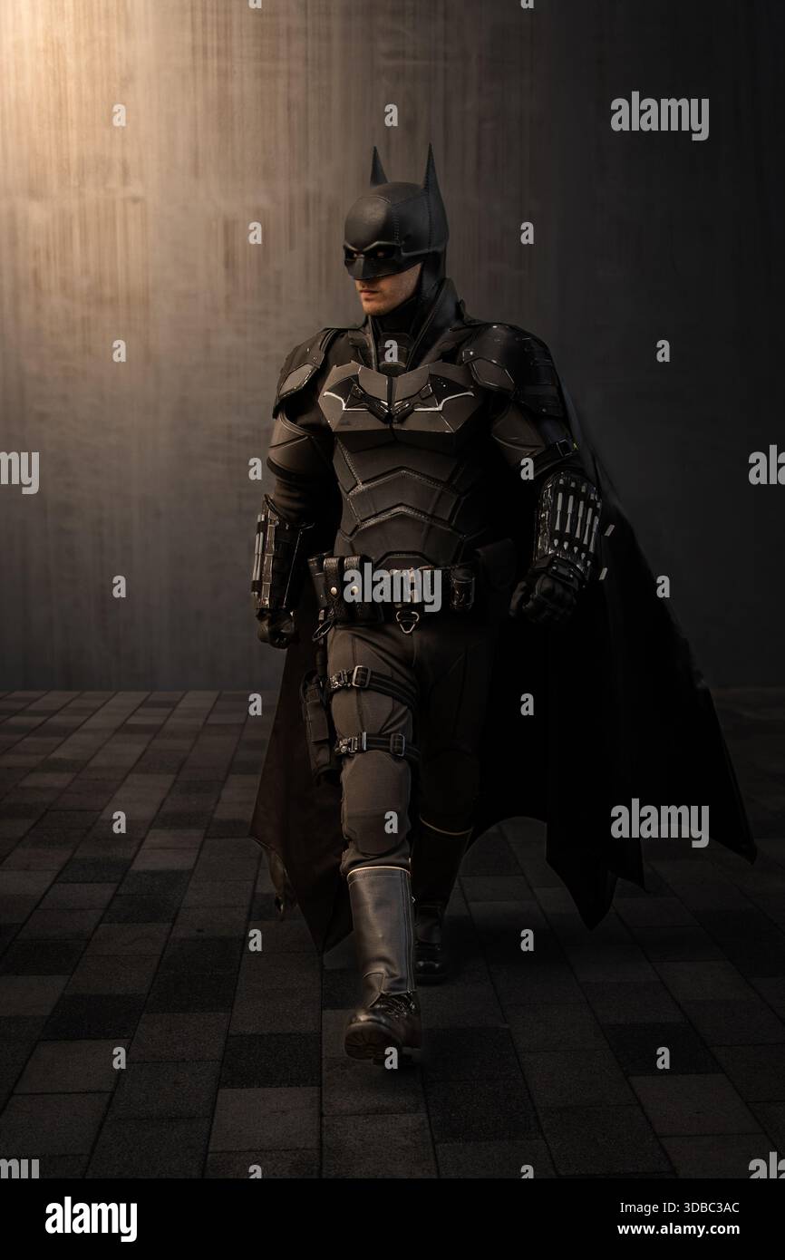 LIVERPOOL, REGNO UNITO - 16 NOVEMBRE 2025. Un uomo cosplay Batman del Cavaliere Oscuro che indossa un costume e una maschera realistici in una posa d'azione a piedi con spazio copia e BL Foto Stock