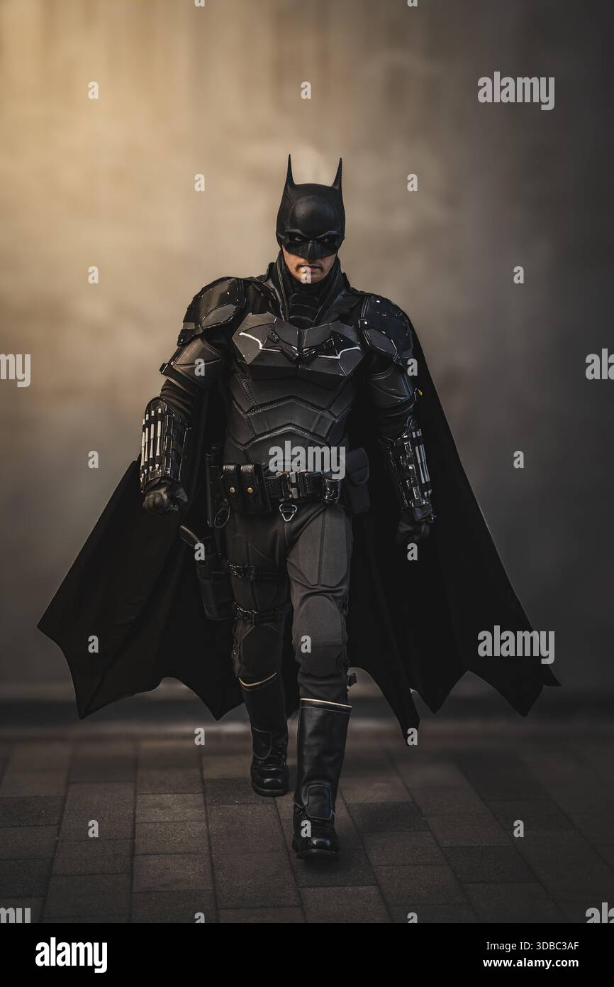 LIVERPOOL, REGNO UNITO - 16 NOVEMBRE 2025. Un uomo cosplay Batman del Cavaliere Oscuro che indossa un costume e una maschera realistici in una posa d'azione a piedi con spazio copia e BL Foto Stock