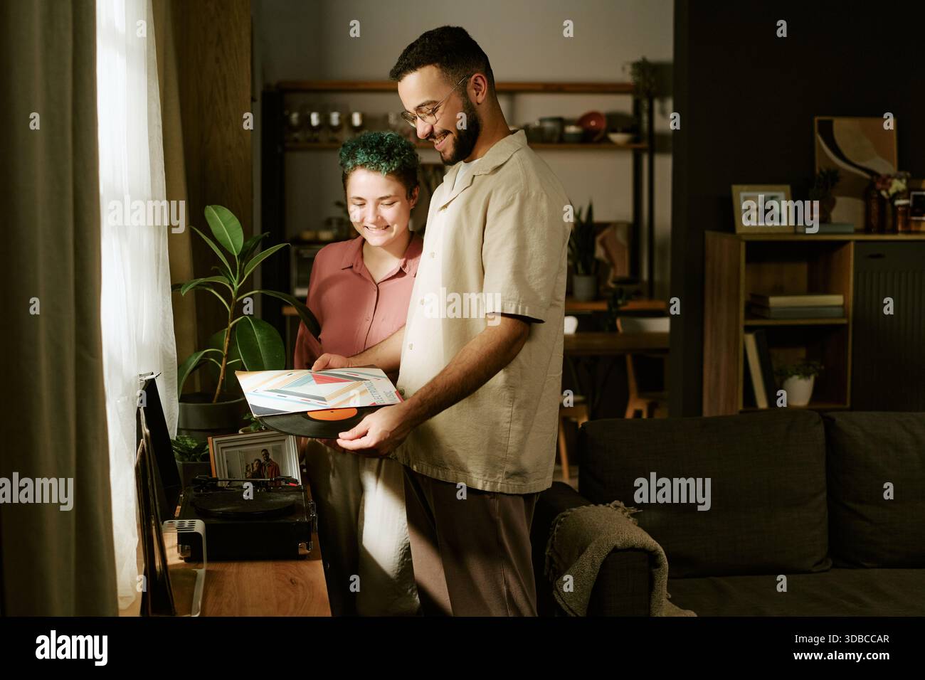 Young Woman e Young Man ascoltano insieme la Vinyl Records Foto Stock
