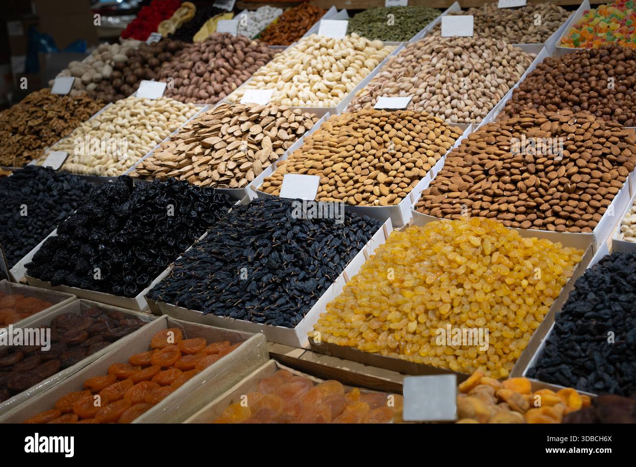 Esposizione sul mercato di frutta a guscio e frutta secca assortite in vassoi: Mandorle, pistacchi, anacardi, nocciole, noci, uvetta dorata e nera, albicocche secche Foto Stock