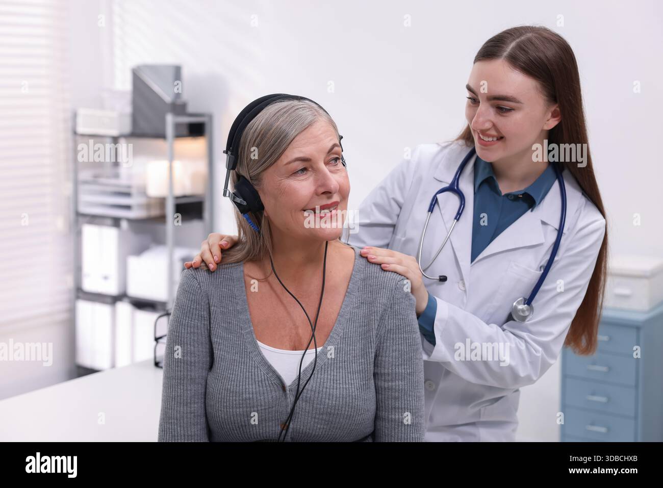 Paziente con cuffie audiometriche sottoposto a test uditivo in clinica Foto Stock