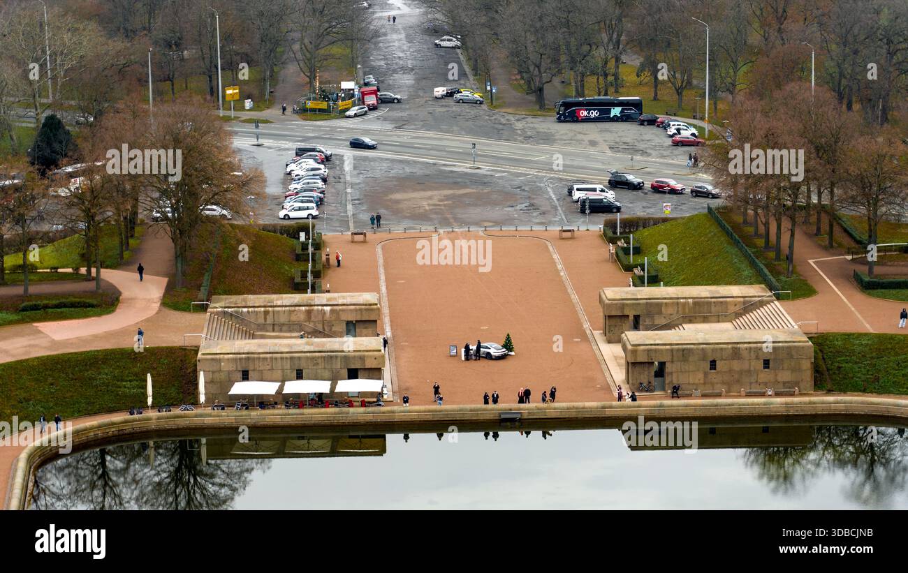 Vista di un ingresso al parco e di una strada con veicoli e persone, di fronte al lago delle lacrime al Völkerschlachtdenkmal. Foto Stock