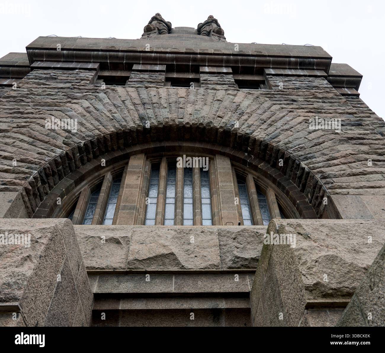 Muratura in pietra con un'imponente finestra ad arco e intricati dettagli architettonici, un dettaglio ravvicinato del Völkerschlachtdenkmal. Foto Stock