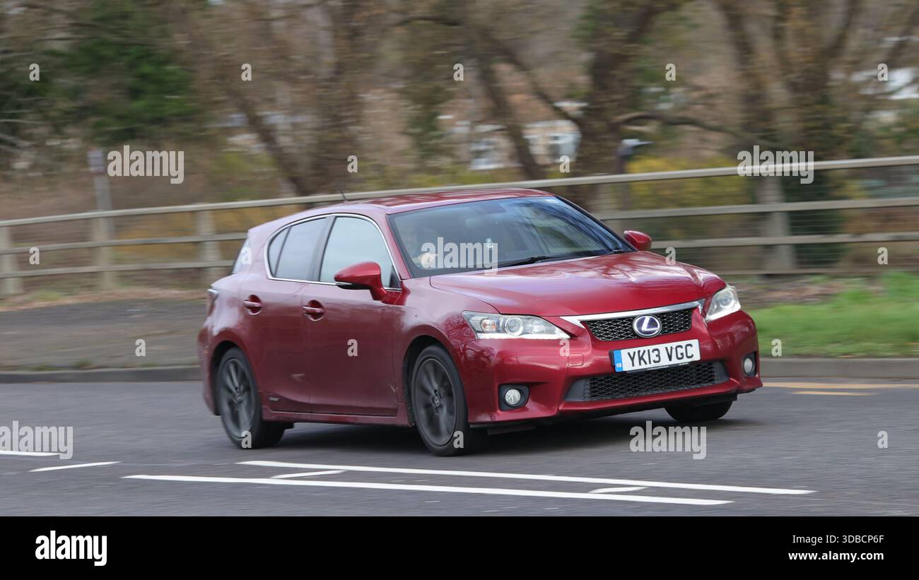 Milton Keynes,Bucks,UK - 11 dicembre 2025: 2013 auto elettrica ibrida Lexus CT rossa che guida su una strada britannica Foto Stock
