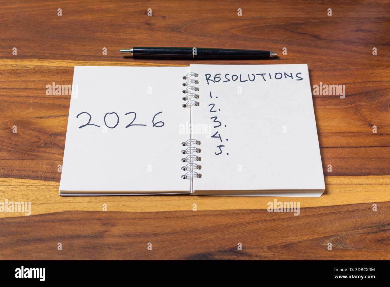 Concetto di Capodanno 2026. Quaderno e penna su un tavolo di legno Foto Stock