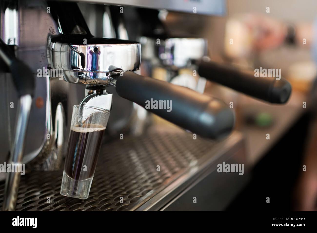 Espresso appena preparato dalla macchina da caffè professionale in caffetteria, primo piano Foto Stock