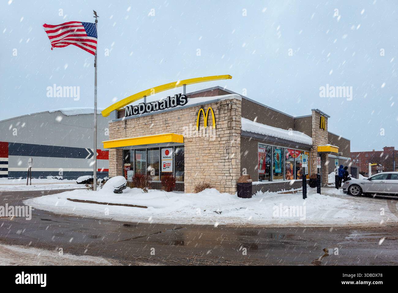Utica, NY - 9 dicembre 2025: Una vista invernale nevicata del McDonald's Restaurant come concetto di calore e intrattenimento gastronomico dal freddo, questo sito è Foto Stock