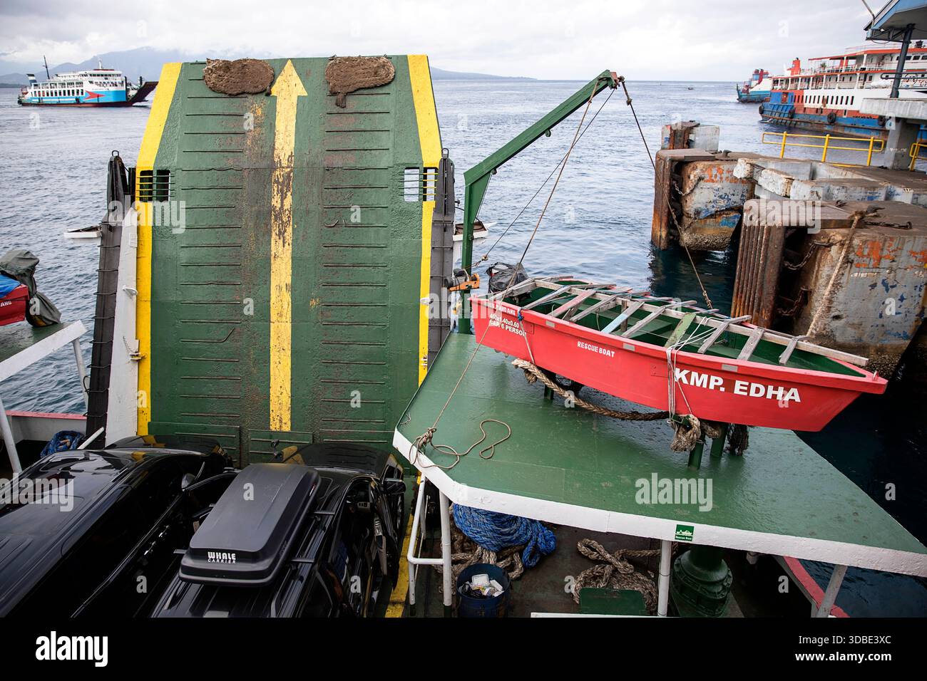 Ponte di un traghetto indonesiano con battello di soccorso, rampa per veicoli e auto parcheggiate in un porto, traghetto per Java a Bali, Indonesia Foto Stock