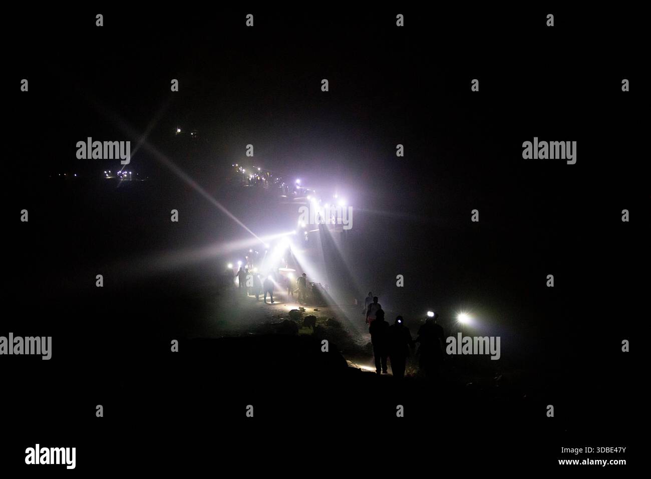 Enorme numero di visitatori, turisti che camminano fino alla cima del vulcano Ijen per vedere la luce blu nel cratere del vulcano, passeggiata notturna fino alla cima, jawa, indonesia Foto Stock