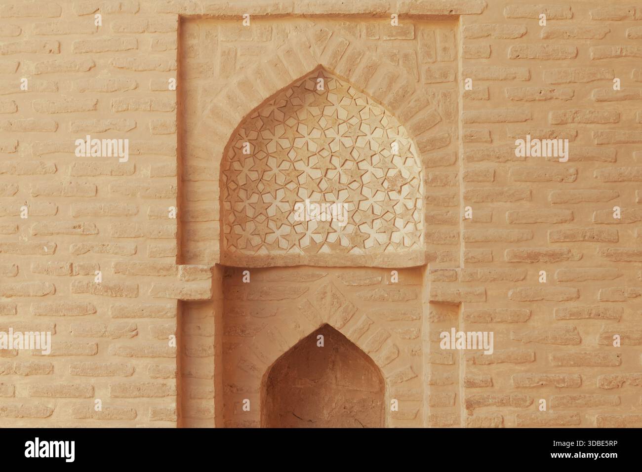 Intricate murature della Moschea Jameh di Zavareh, Iran. L'arco decorativo con motivi geometrici mostra l'eleganza dell'architettura persiana dell'epoca selgiuchide. Foto Stock