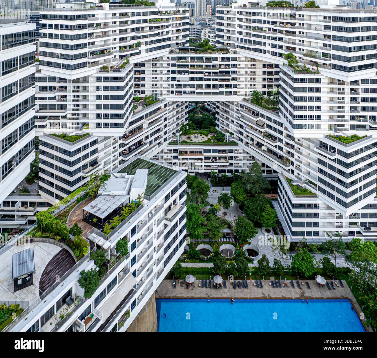 La vista aerea dell'architettura sovrapposta dell'Interlace Condominium crea uno schema ipnotico contro il lussureggiante paesaggio verde di Singapore. Foto Stock