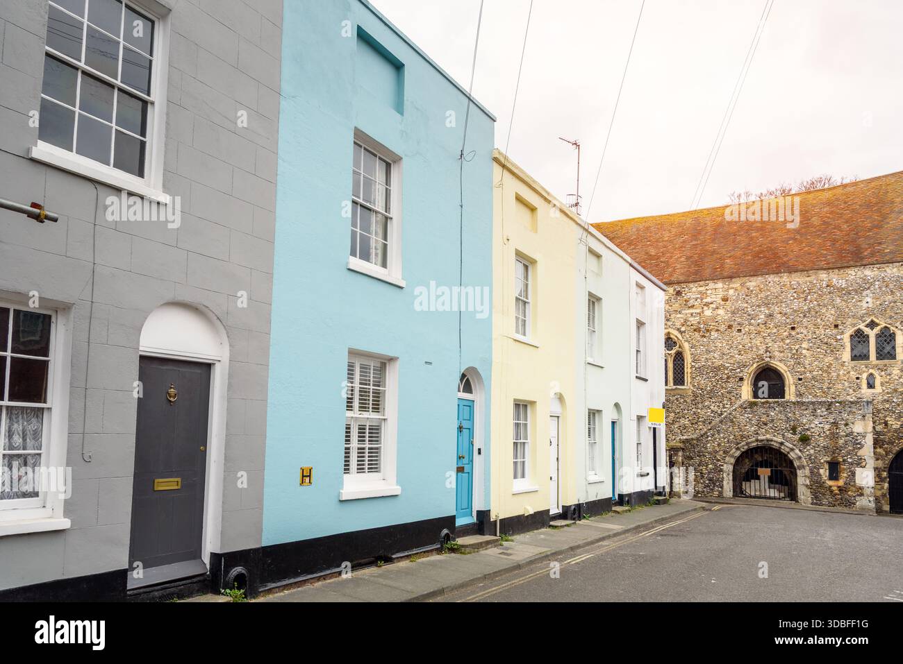 Fila di case colorate a schiera nel centro storico della città. Un vero cartello este letto venduto e' fuori dall'ultima casa della fila. Foto Stock
