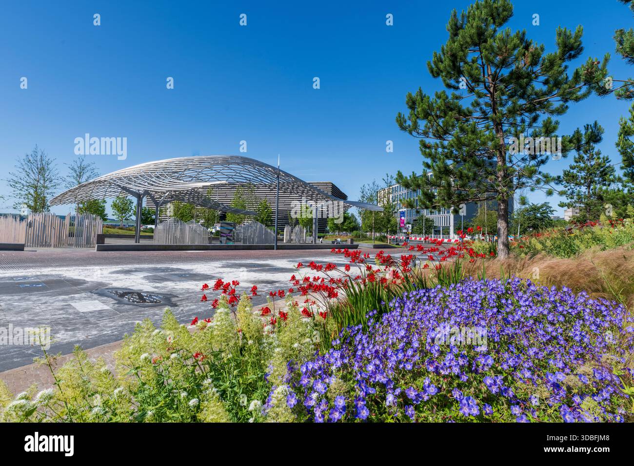 I giardini sul lungomare presentano un elegante e moderno padiglione, lussureggianti aiuole di fiori e un'ampia piazza aperta. Una giornata luminosa e soleggiata mette in risalto i fiori rossi e viola Foto Stock