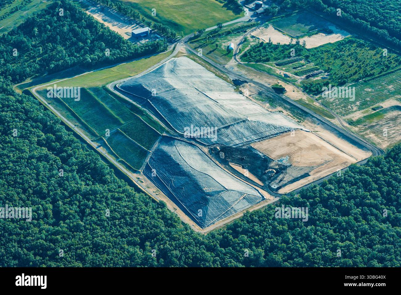La vegetazione lussureggiante circonda i vasti strati di una discarica nella contea di Manistee, a dimostrazione della combinazione di natura e sforzi di gestione dei rifiuti. Foto Stock