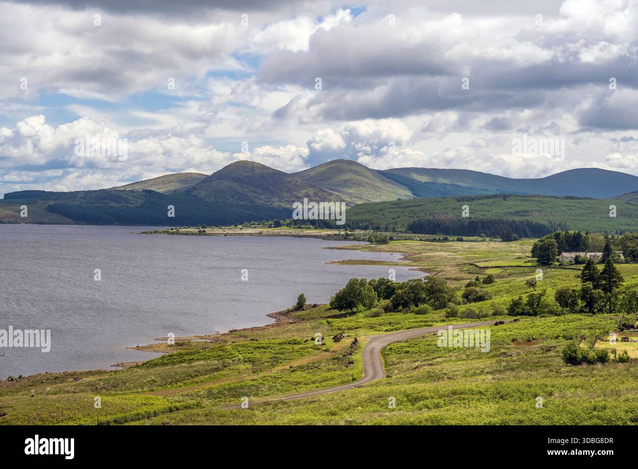 Scenografica scena sul lago scozzese di Loch Doon con una strada tortuosa e colline verdeggianti. Foto Stock
