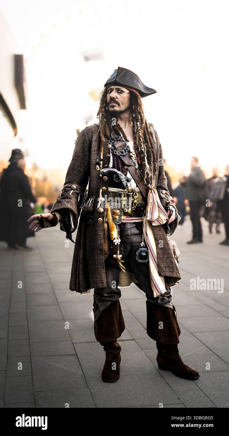 Un ritratto ravvicinato di un cosplayer maschile vestito da capitano Jack Sparrow dei Pirati dei Caraibi che sembra felice e divertente Foto Stock