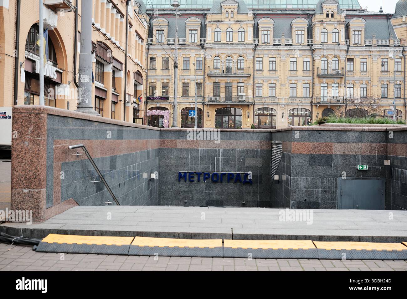 Una vivace scena cittadina che mostra l'ingresso della metropolitana vicino all'architettura storica. Metrograd. Kiev, Ucraina. 16 dicembre 2025. Foto Stock