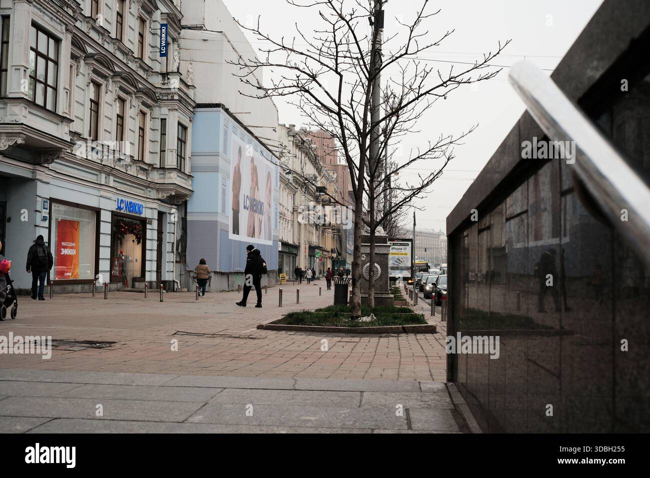 Le persone passeggiano lungo il marciapiede in un vivace centro della città in una giornata nuvolosa. Kiev, Ucraina. 16 dicembre 2025. Foto Stock