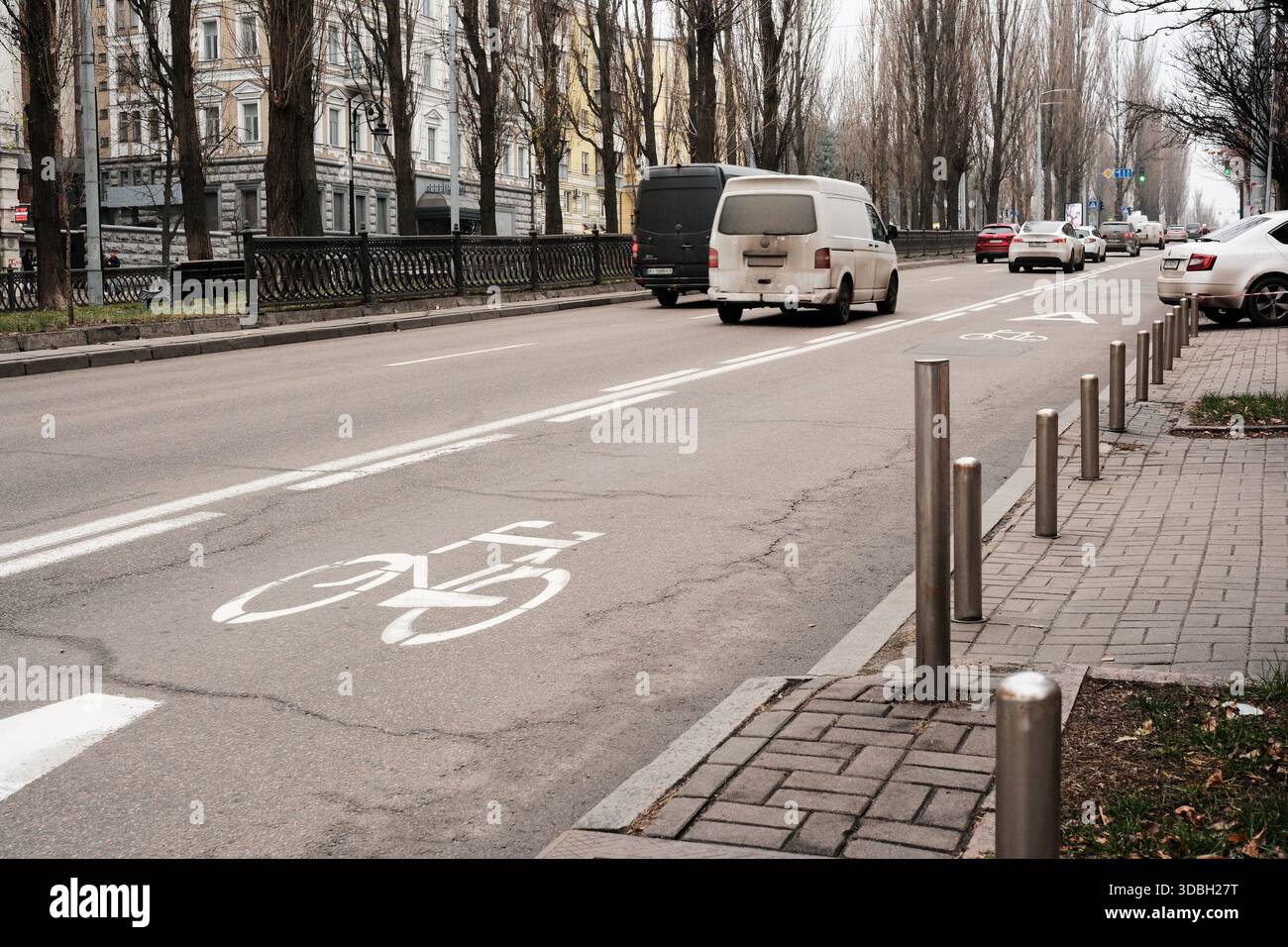 I veicoli navigano lungo le piste ciclabili in una strada urbana trafficata in inverno. Shevchenko Boulevard. Kiev, Ucraina. 16 dicembre 2025. Foto Stock