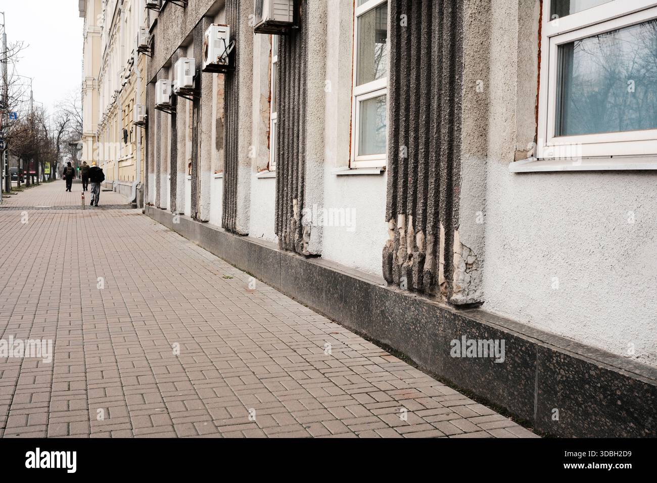 Le pareti incrinate e gli strati sbucciati raccontano storie del tempo su un tranquillo marciapiede della città. Shevchenko Boulevard. Kiev, Ucraina. 16 dicembre 2025. Foto Stock