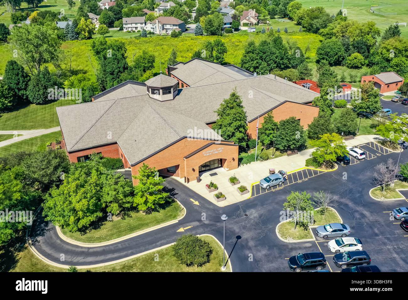 Vista aerea della biblioteca pubblica dell'area di Algonquin che mostra una biblioteca locale in mattoni, giardini paesaggistici e il quartiere periferico circostante. Foto Stock