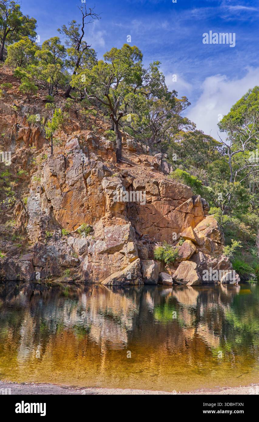 Scogliera di arenaria rocciosa riflessa nella diga di Graham nella gola del fiume Lerderderg in una giornata di sole, nel parco nazionale Wombat-Lerderderg, Victoria, Australia Foto Stock