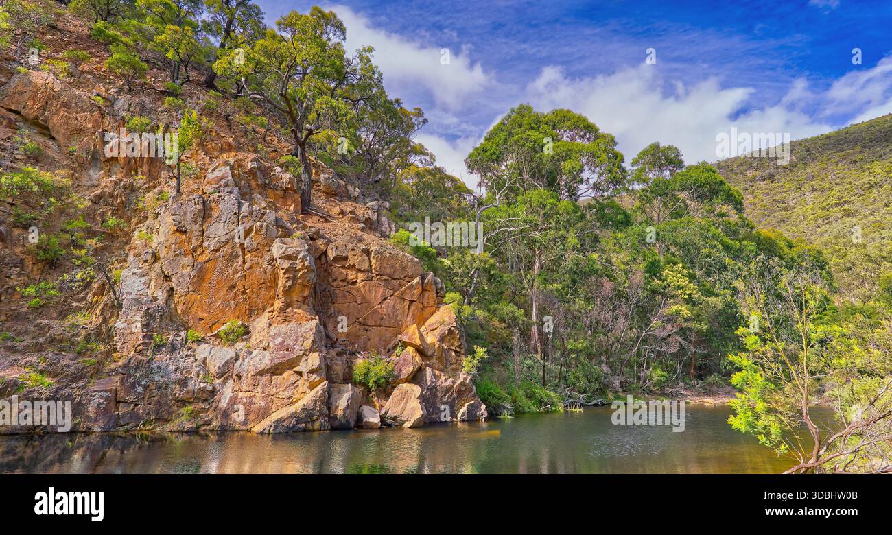 Scogliera di arenaria rocciosa riflessa nella diga di Graham nella gola del fiume Lerderderg in una giornata di sole, nel parco nazionale Wombat-Lerderderg, Victoria, Australia Foto Stock