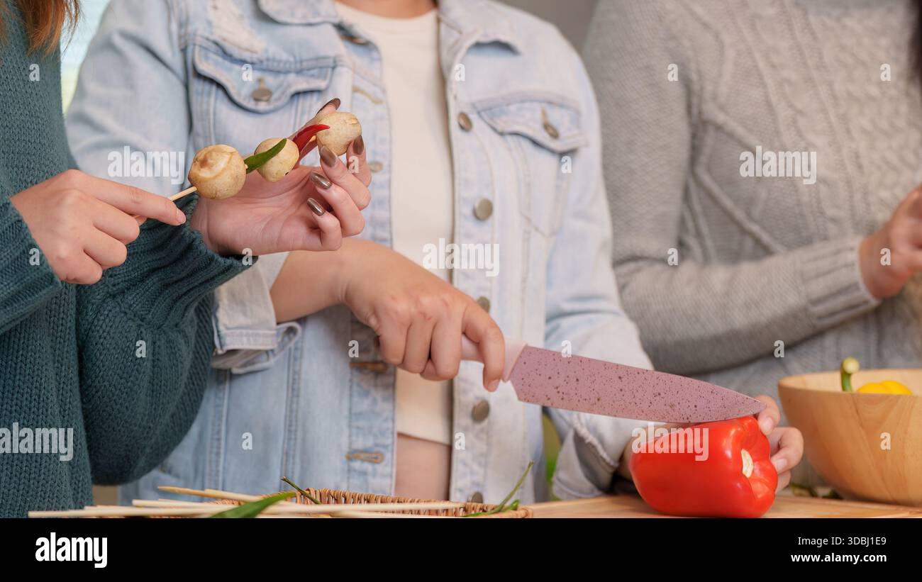 Prepararsi alla festa con gli amici cucinando e gustando il cibo insieme Foto Stock