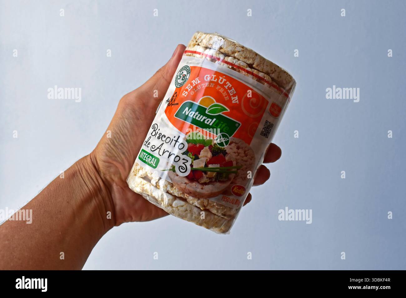 RIO DE JANEIRO, BRASILE - 28 novembre 2025: Mano che regge un pacchetto di torte di riso rotonde Foto Stock