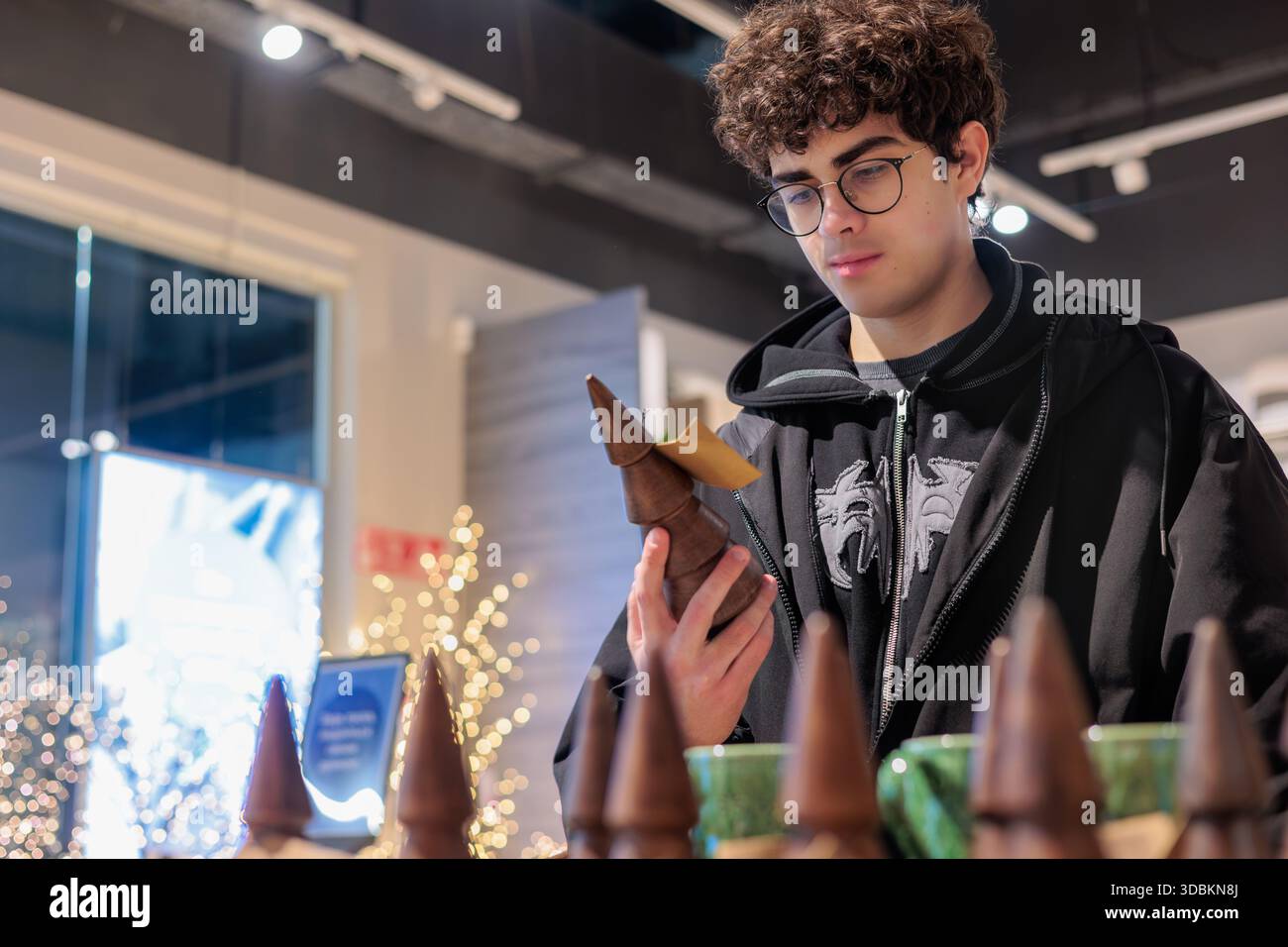 Adolescente che sceglie la decorazione in legno per le vacanze nel negozio di articoli per la casa - shopping stagionale. Shopping natalizio nel negozio al dettaglio. JYSK. Leopoli 11.11.2025 Foto Stock