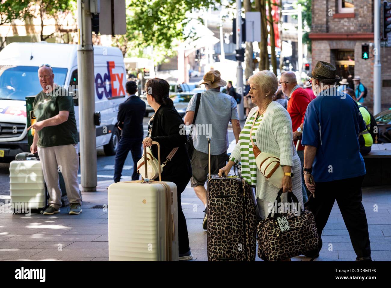 I turisti con le loro valigie su Bathurst Street, Central Business District, Sydney, NSW, Australia Foto Stock