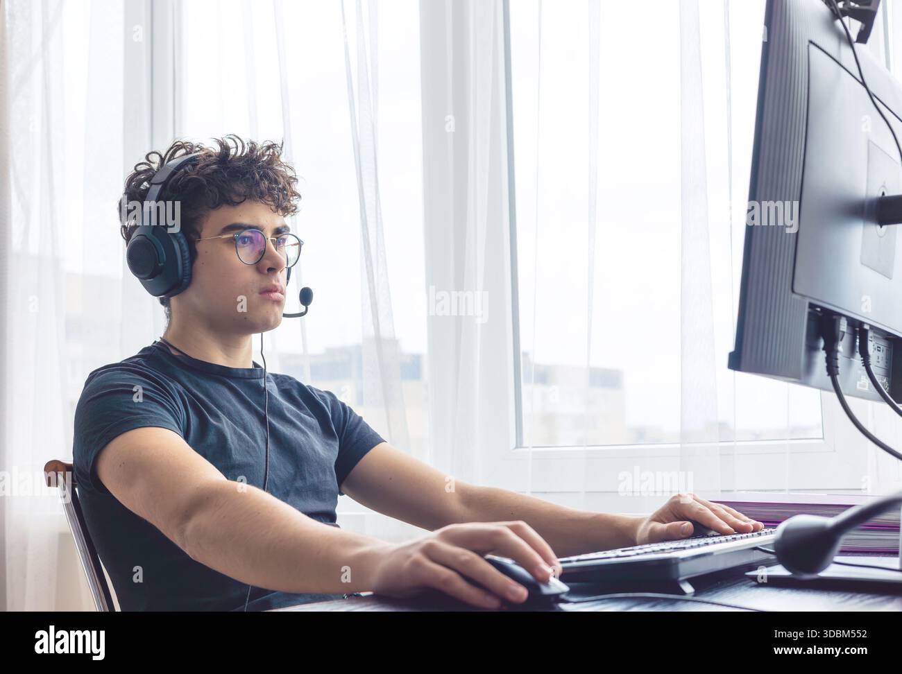 Teenager giocatore di eSport che si concentra su un gioco. Adolescenti che utilizzano la tecnologia per l'apprendimento e il gaming. Videogamer adolescente che gioca su un computer. Imparare online a casa. prigioniero Foto Stock