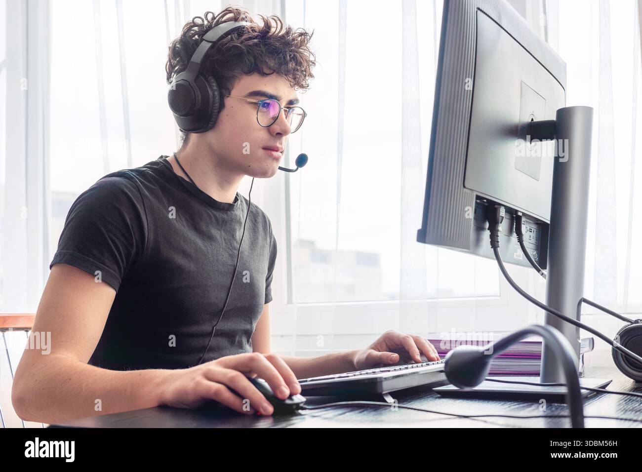 Teenager giocatore di eSport che si concentra su un gioco. Adolescenti che utilizzano la tecnologia per l'apprendimento e il gaming. Videogamer adolescente che gioca su un computer. Imparare online a casa. prigioniero Foto Stock