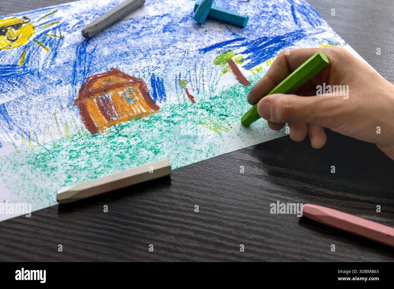Focused Child in Green T-shirt Drawing with Crayons - Art Therapy for Autism, ADHD e Digital Detox Concept. ragazzo che disegna con colori pastello. Foto Stock