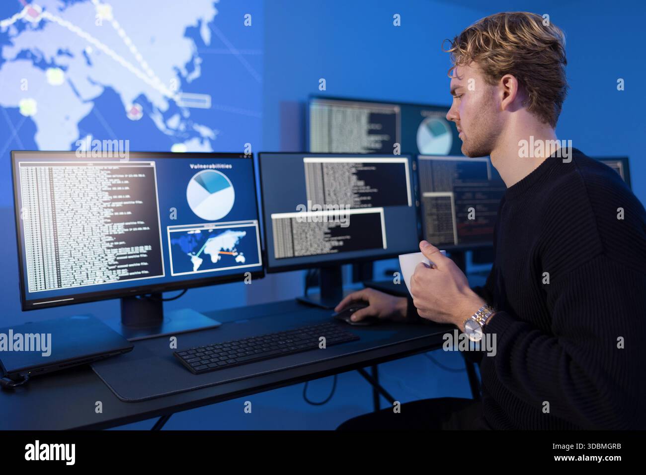 Sistemi di monitoraggio degli analisti di sicurezza informatica in un centro operativo sicuro Foto Stock