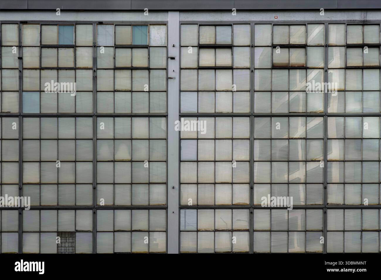 Echi dell'industria: Un mosaico di storia. A Zurigo, in Svizzera, la facciata Maag-Halle mostra vetri opachi che ricordano il suo passato industriale. I riflessi delle strutture moderne fondono la storia con il presente. Foto Stock