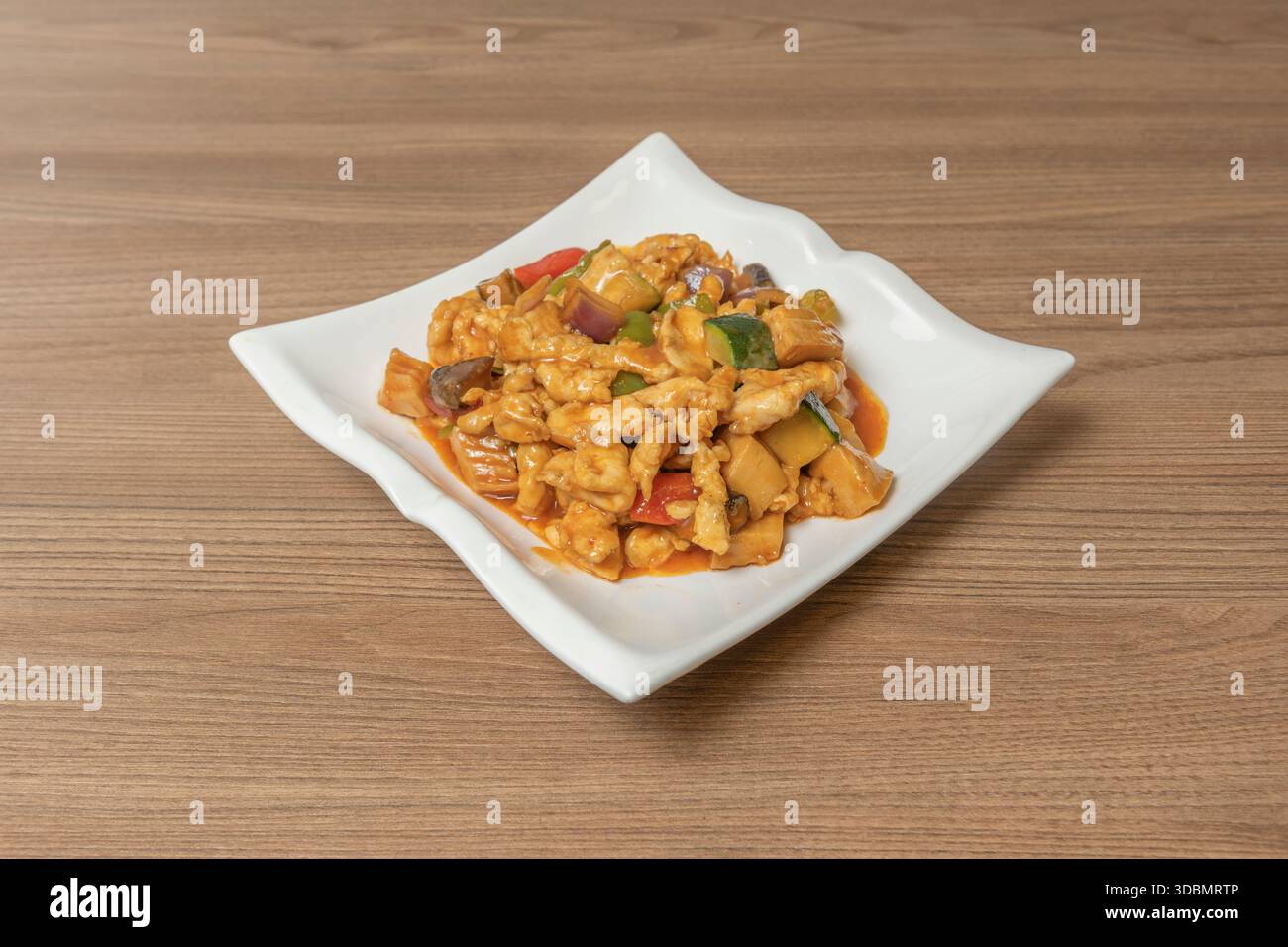 Autentico pollo Kung Pao con arachidi tostate, peperoncini secchi interi e salsa di soia scura, servito in un recipiente di ceramica con riso al vapore Foto Stock