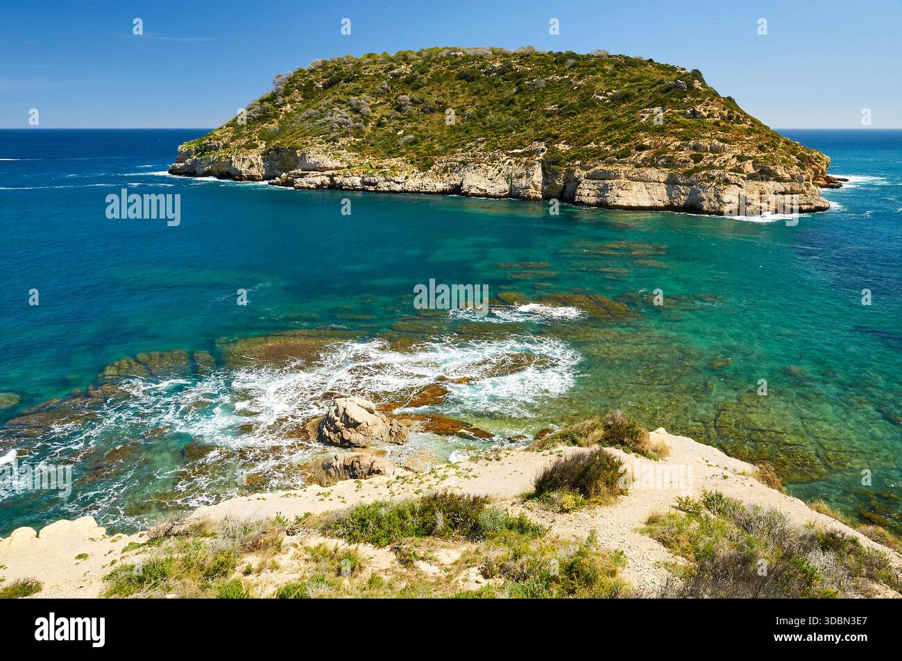 Isola dell'Isla del Portitxol e onde che si infrangono sulle rocce dal punto panoramico del Mirador del Portichol (Jávea, Marina alta, Alicante, Mar Mediterraneo, Spagna) Foto Stock